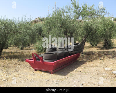 Les constructeurs rouge saute avec pneus en caoutchouc sur le terrain vague près de Alora Andalousie Banque D'Images