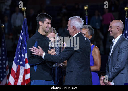 John McEnroe, présente le trophée à Novak Djokovic (SRB) pour la finale chez les hommes à l'US Open de Tennis 2018. Banque D'Images