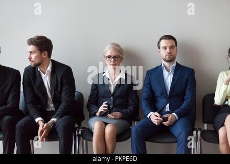 Les candidats jeunes et matures en attente d'entrevue d'emploi in office Banque D'Images