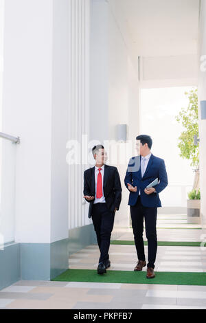 Deux hommes vietnamiens coworkers talking and smiling Banque D'Images