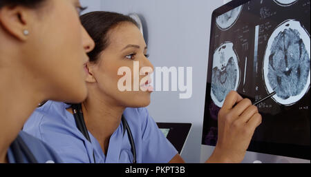 Portrait de deux femmes médecins qui travaillent ensemble sur des scans du cerveau de l'ordinateur Banque D'Images