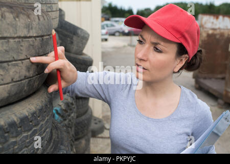 Femme contrôle de la voie sur pneu de voiture avec manomètre Banque D'Images