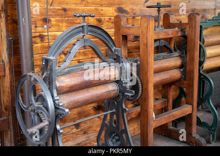 Vieux mangle des travaux domestiques. Les appareils qui facilitent les tâches ménagères dans une maison ancienne. La saison de printemps. Banque D'Images