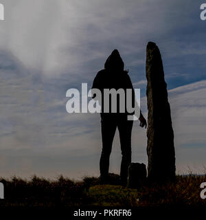 Silhouette encapuchonnée se tenait près de standing stone, Yorkshire du nord Banque D'Images