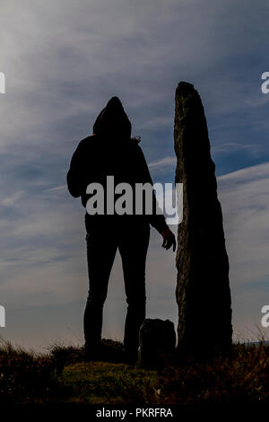 Silhouette encapuchonnée se tenait près de standing stone, Yorkshire du nord Banque D'Images