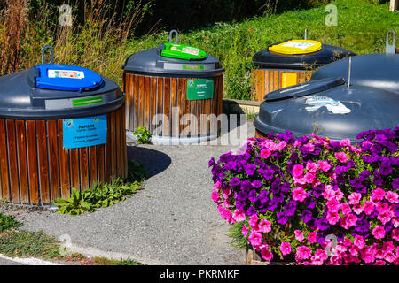 De grands bacs de recyclage plastique en couleur avec des fleurs violettes Chantemerle, Serre Chevalier ski resort, Briancon, France Banque D'Images