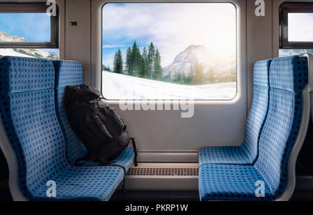 Image concept voyage d'hiver avec 83 chaises, un sac à dos et un paysage d'hiver vu depuis la fenêtre, sur une frontière allemande en train. Banque D'Images