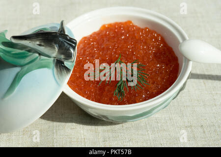 Grand caviar rouge dans une belle icône de porcelaine sur une nappe gris. L'alimentation, de délicatesse Banque D'Images