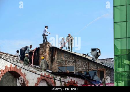 15 septembre 2018 - Srinagar, J&K, Inde - Les sections locales et les pompiers vu sur le toit d'essayer d'éteindre le feu.Un violent incendie a éclaté dans un hôtel local ici à Srinagar le samedi, mais il n'y a pas eu de perte de vie ou blessures selon la police. Offres d'incendie ont été transportés à l'endroit et de la police, et l'incendie et d'urgence tentaient d'éteindre les flammes. Credit : Saqib Majeed/SOPA Images/ZUMA/Alamy Fil Live News Banque D'Images