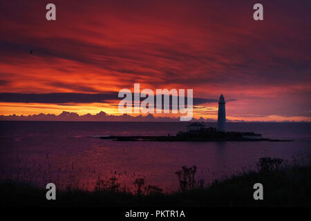 Le soleil se lève derrière le phare de St Mary's en Whitley Bay, Tyne et Wear. Banque D'Images