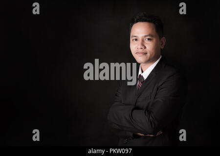 Portrait Asian businessman contre son bras et sourire avec confiance Banque D'Images