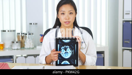 Médecin Chinois parlant à huis clos avec les rayons x sur tablette Banque D'Images