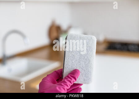 Femme mains en portant des gants protecteurs et la tenue d'éponge de nettoyage on white background cuisine. Concept de cuisine Banque D'Images