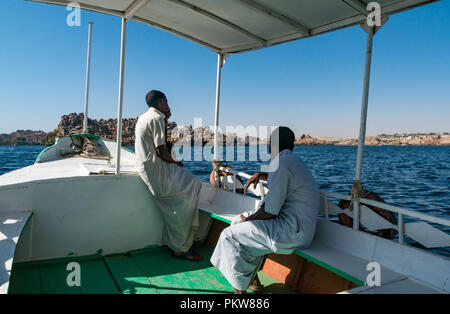 Bateau de tourisme avec les hommes égyptiens sur lac Nasser aller à Temple de Philae, l'Île Agilkia, Nil, l'Egypte, l'Afrique Banque D'Images
