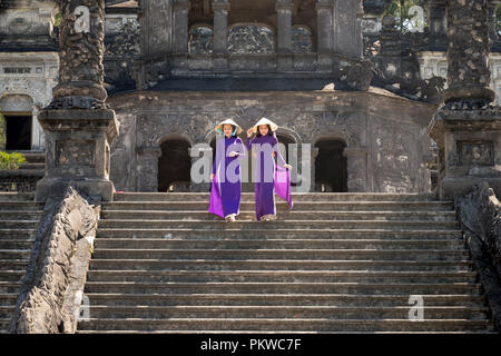 Deux jeunes filles vietnamiennes sont douces en robe pourpre traditionnel de la culture sur la tombe du roi Khai Dinh à la ville de Hue, Vietnam Banque D'Images