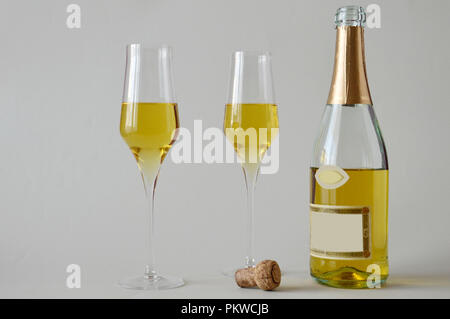 Deux verres et une bouteille de vin mousseux sur fond blanc Banque D'Images