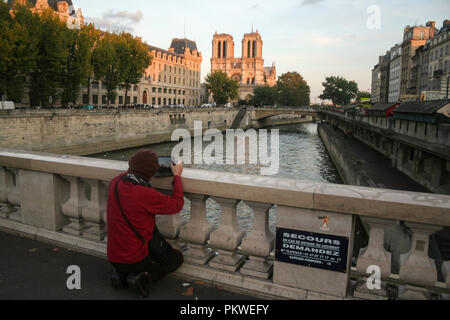 PARIS, FRANCE - 11 octobre 2014 : Office de prendre une photo de la Cathédrale Notre Dame de Paris à partir d'un pont sur la Seine, sur l'Ile de la Cite Islan Banque D'Images