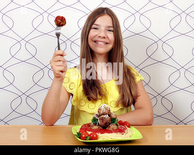 Beautiful happy girl avec des boulettes de viande et des spaghettis pour le déjeuner Banque D'Images