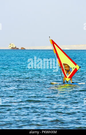 Planche à voile, une mer bleue et voile jaune. L'exercice de surfer dans l'océan ou mer calme Banque D'Images