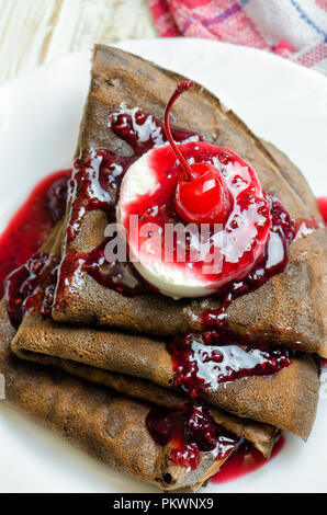 Crêpes au chocolat avec de la glace et de la confiture de framboises. Banque D'Images