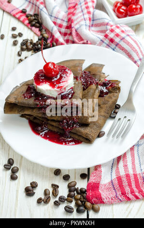 Crêpes au chocolat avec de la glace et de la confiture de framboises. Banque D'Images