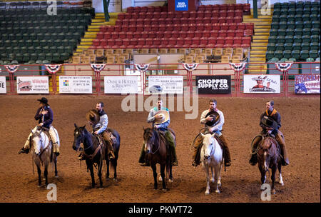 Staycation. Les cow-boys à cheval placent des chapeaux à cœur et écoutent l'hymne national américain au spectacle de rodéo sauvage de Pawnee Bill's Wild West. Pi. Vaut le Texas. Banque D'Images
