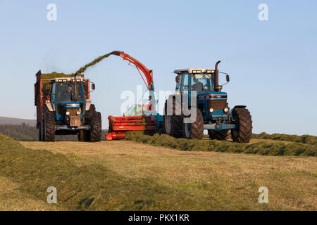 1993 Ford 8630  + Reco Mengele SH40N, 1990 Ford 6810 avec remorque 8 tonnes Teagle karting l'ensilage à l'écart dans une remorque sur une ferme laitière en Angleterre Banque D'Images