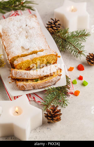 Pain de Noël avec des fruits confits et de sucre en poudre dans les décorations de Noël. Banque D'Images