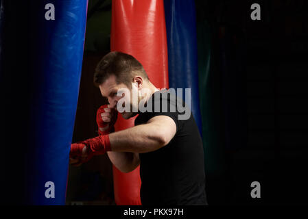 Sac de boxe boxe homme de race blanche sur fond de sport moderne Banque D'Images