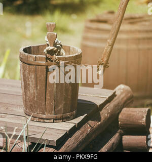 Ancien seau en bois debout sur le bien, close-up Banque D'Images