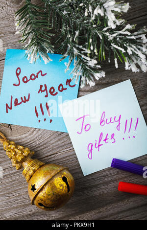 Des autocollants avec des notes sur les vacances de Noël sur un fond de bois, vue du dessus. Un rappel de l'approche de la nouvelle année Banque D'Images