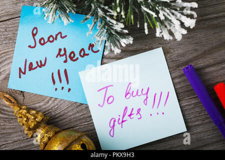 Des autocollants avec des notes sur la nouvelle année sur un fond de bois, vue du dessus. Un rappel de l'approche des vacances de Noël Banque D'Images