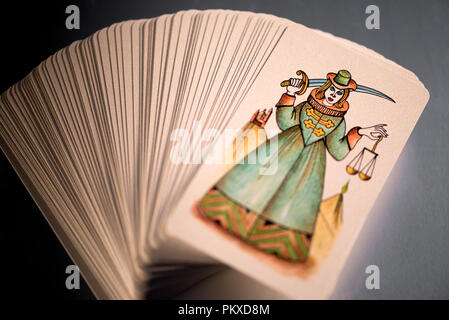 Les cartes de tarot empilées montrant une carte illustrée d'une femme à l'épée et d'une balance de la Justice, la loi symbolique et la répression dans un plan rapproché sur Banque D'Images