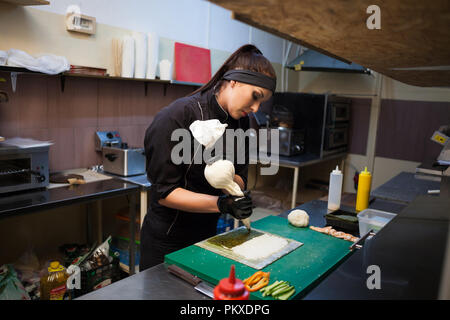 Femme cuisinier prépare des sushis sur une cuisine de restaurant Banque D'Images