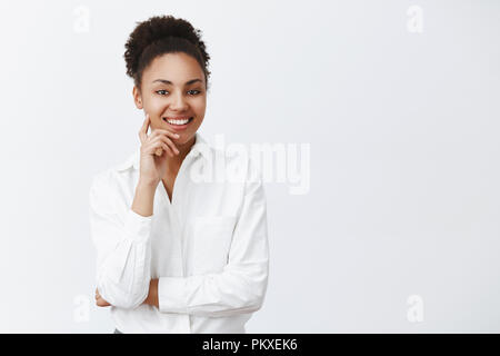 Beau succès de la peau sombre femme entrepreneur de l'écoute polie et gentil sourire employé, une demande de nouvel emploi, d'entrevue, la personne tenant le doigt sur la joue et tout sourire Banque D'Images
