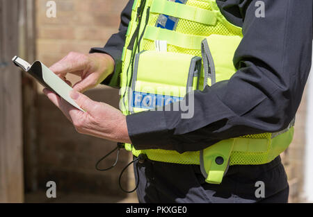 Vue rapprochée d'une femme agent de police tenant un ordinateur portable noir, Banque D'Images