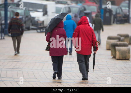 Aberystwyth, Pays de Galles, Royaume-Uni. 16 septembre 2018 UK Weather : personnes marchant le long de la promenade du front de mer à Aberystwyth , Pays de Galles sur un morne et humide dimanche après-midi de septembre. L'ouest de la France se prépare donc pour l'impact de la tempête Hélène, qui est prévu de faire la grève du jour au lendemain, le lundi, avec des vents soufflant jusqu'à 70 mi/h dans les zones exposées, , avec le risque de danger à la vie à partir de la projection de débris Photo © Keith Morris / Alamy Live News Banque D'Images