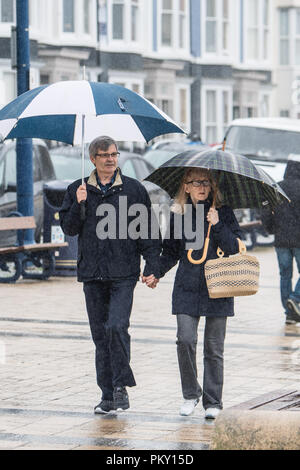 Aberystwyth, Pays de Galles, Royaume-Uni. 16 septembre 2018 UK Weather : personnes marchant le long de la promenade du front de mer à Aberystwyth , Pays de Galles sur un morne et humide dimanche après-midi de septembre. L'ouest de la France se prépare donc pour l'impact de la tempête Hélène, qui est prévu de faire la grève du jour au lendemain, le lundi, avec des vents soufflant jusqu'à 70 mi/h dans les zones exposées, , avec le risque de danger à la vie à partir de la projection de débris Photo © Keith Morris / Alamy Live News Banque D'Images