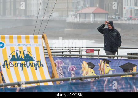 Aberystwyth, Pays de Galles, Royaume-Uni. 16 septembre 2018 UK Weather : personnes marchant le long de la promenade du front de mer à Aberystwyth , Pays de Galles sur un morne et humide dimanche après-midi de septembre. L'ouest de la France se prépare donc pour l'impact de la tempête Hélène, qui est prévu de faire la grève du jour au lendemain, le lundi, avec des vents soufflant jusqu'à 70 mi/h dans les zones exposées, , avec le risque de danger à la vie à partir de la projection de débris Photo © Keith Morris / Alamy Live News Banque D'Images