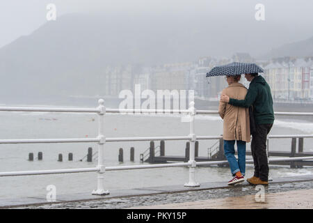 Aberystwyth, Pays de Galles, Royaume-Uni. 16 septembre 2018 UK Weather : personnes marchant le long de la promenade du front de mer à Aberystwyth , Pays de Galles sur un morne et humide dimanche après-midi de septembre. L'ouest de la France se prépare donc pour l'impact de la tempête Hélène, qui est prévu de faire la grève du jour au lendemain, le lundi, avec des vents soufflant jusqu'à 70 mi/h dans les zones exposées, , avec le risque de danger à la vie à partir de la projection de débris Photo © Keith Morris / Alamy Live News Banque D'Images