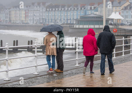 Aberystwyth, Pays de Galles, Royaume-Uni. 16 septembre 2018 UK Weather : personnes marchant le long de la promenade du front de mer à Aberystwyth , Pays de Galles sur un morne et humide dimanche après-midi de septembre. L'ouest de la France se prépare donc pour l'impact de la tempête Hélène, qui est prévu de faire la grève du jour au lendemain, le lundi, avec des vents soufflant jusqu'à 70 mi/h dans les zones exposées, , avec le risque de danger à la vie à partir de la projection de débris Photo © Keith Morris / Alamy Live News Banque D'Images