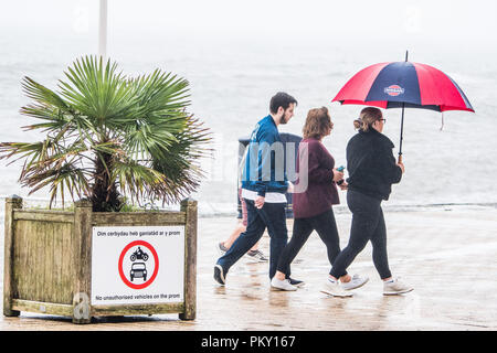 Aberystwyth, Pays de Galles, Royaume-Uni. 16 septembre 2018 UK Weather : personnes marchant le long de la promenade du front de mer à Aberystwyth , Pays de Galles sur un morne et humide dimanche après-midi de septembre. L'ouest de la France se prépare donc pour l'impact de la tempête Hélène, qui est prévu de faire la grève du jour au lendemain, le lundi, avec des vents soufflant jusqu'à 70 mi/h dans les zones exposées, , avec le risque de danger à la vie à partir de la projection de débris Photo © Keith Morris / Alamy Live News Banque D'Images