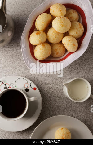 Vue de dessus d'un simple petit-déjeuner brésilien, avec café, lait et fromage pain (également connu sous le nom de Pão de Queijo). Banque D'Images