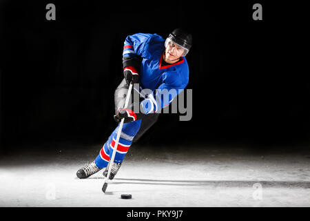 Jeune joueur de hockey Patinage sur glace dans l'attaque Banque D'Images