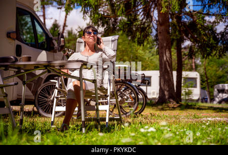 Femme parlant au téléphone intelligent à l'extérieur dans un camping pour les vacanciers. Location caravane Vacances. Vacances famille vacances, voyages voyage en camping-car. Con Banque D'Images