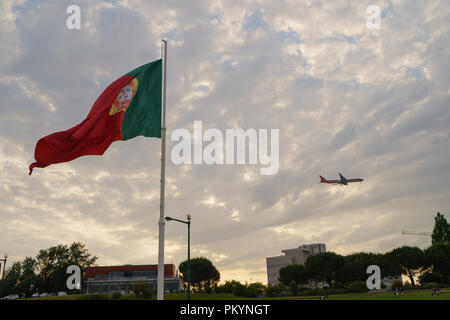 Blowing pavillon portugais sur place de l'Espagne à Lisbonne, ressemble à la zone de l'aéroport, l'avion décollant ou atterrissant à proximité Banque D'Images