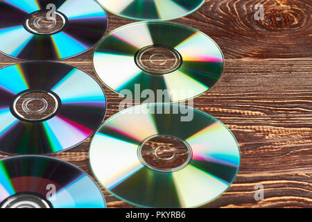 Groupe de disques compact, coloré et copier l'espace. De nombreux disques cd et dvd brillant sur fond de bois de près. Médias numériques des dvd. Banque D'Images