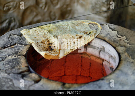 L'Arménie, de l'accueil faite cuire du pain lavash sur un plancher traditionnel arménien four Banque D'Images