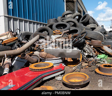 Une pile de pièces de véhicules jetées et pneumatiques pour le recyclage dans le Nord de New York, USA. Banque D'Images