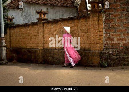 Une charmante femme dans un ao dai dans l'ancien village de Duong Lam. Ha Noi capital, Vietnam Banque D'Images